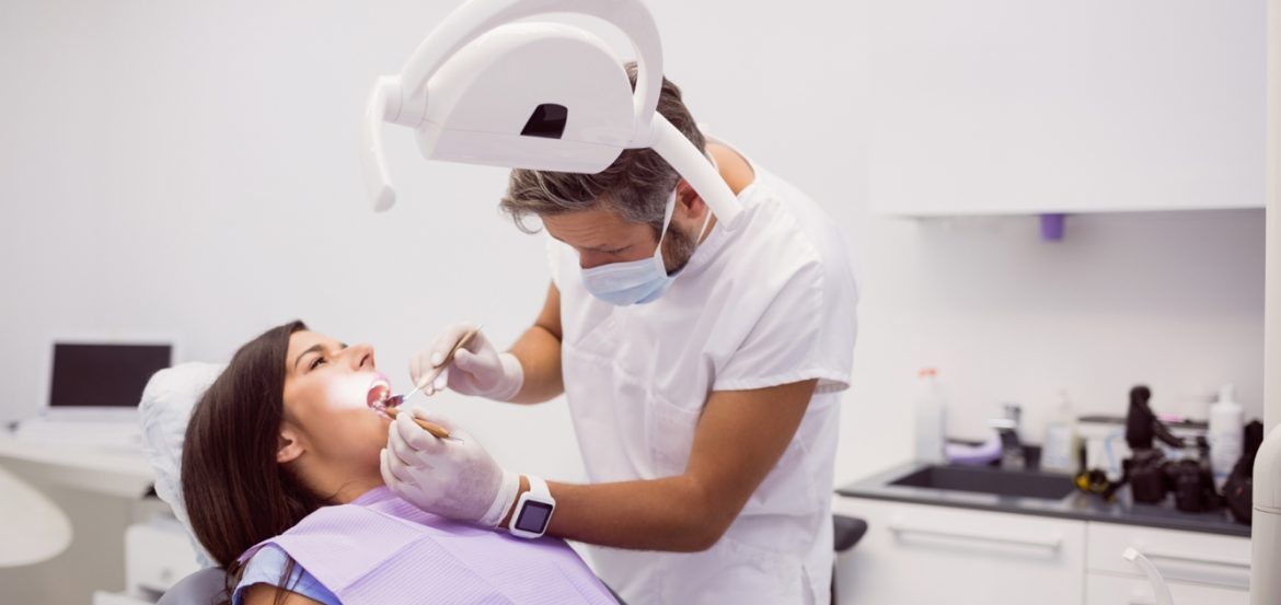 dentist-examining-female-patient-teeth