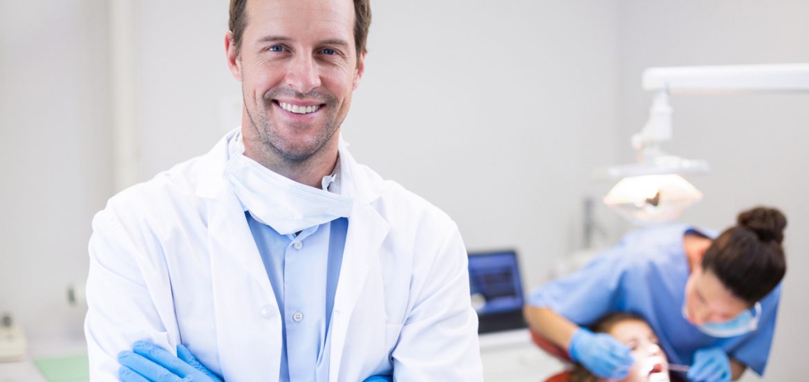 dentist-standing-with-arms-crossed-clinic