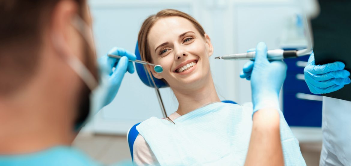 woman-sits-dental-chair-doctors-bowed-her